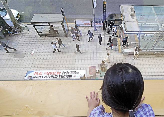 26일 서울 강남구 역삼동에 있는 쿠팡 어린이집 앞에서 택배노조가 집회를 개최한 가운데 어린이가 창밖을 바라보고 있다. <사진=독자 제공>