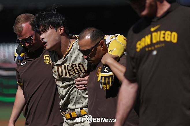 김하성(가운데)이 26일(한국시간) 워싱턴 내셔널스와 원정 경기에서 2회 자신의 파울 타구에 무릎을 강타당한 뒤 트레이너 2명의 부축을 받으며 그라운드를 빠져나가고 있다. /AFPBBNews=뉴스1