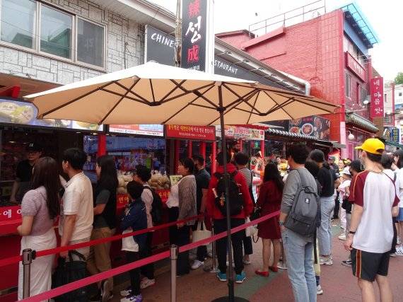 차이나타운 내 공갈빵 가게 앞에 공갈빵을 사려는 관광객이 줄을 서서 순서를 기다리고 있다.