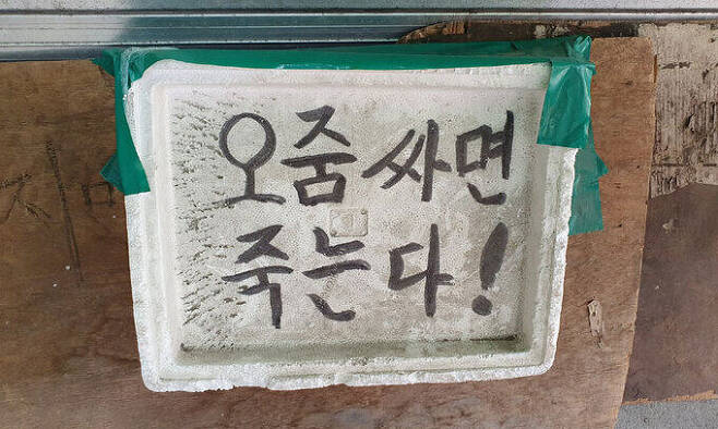 지난 22일 서울 동대문구 청량리청과물시장 내 한 가게 앞에서 ‘오줌 싸면 죽는다!’고 적힌 다소 과격한 경고 안내가 붙어 있다.
