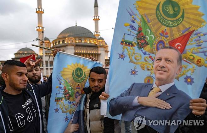 에르도안 재선 축하하는 지지자들 (이스탄불 AFP=연합뉴스) 레제프 타이이프 에르도안 튀르키예 대통령이 28일(현지시간)대선 결선투표에서 승리해 재선에 성공했다. 에르도안 지지자들이 이스탄불 탁심 모스크 앞에서 에르도안 대통령의 재선을 축하하고 있다. 2023.5.28 photo@yna.co.kr