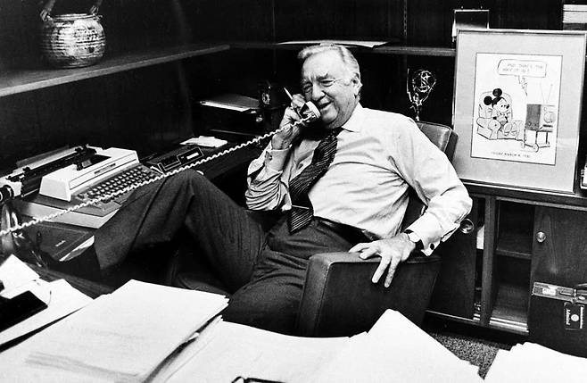월터 크롱카이트가 1981년 3월 6일 저녁 고별 방송 직전 자신의 사무실에서 전화통화하고 있다. 그의 의자 뒤편에 그가 받은 에미상 트로피와 미키 마우스 만화가 보인다. 크롱카이트는 생전에 '미국에서 가장 신뢰받는 사람'으로 꼽혔다./AP