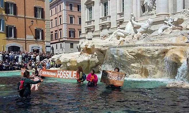 환경단체 울티마 제네라치오네(마지막 세대) 활동가들이 지난 21일(현지시간) 이탈리아 로마에서 명물 트레비분수를 검게 물들이고 있다. AFP연합뉴스