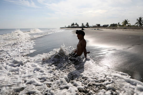 인도네시아 반다아체 시아쿠알라 해변을 찾은 한 피서객이 2023년 5월 16일 파도를 맞으며 더위를 식히고 있다. 이 지역 기상, 기후 및 지구물리학 기관은 엘니뇨로 인한 폭염을 경고하며 야외 활동을 줄이라고 권고했다. / EPA연합뉴스