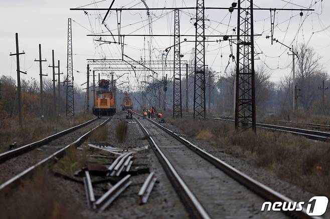 우크라이나 전쟁이 지속되고 있는 가운데 러시아 국경도시 우크라이나 북동부 슬라티네에서 사람들이 부서진 철로를 수리하고 있다. 이는 북동부 60㎞ 떨어진 러시아 벨고로드로 이어진다. 2022.10.25 ⓒ 로이터=뉴스1 ⓒ News1 정윤미 기자