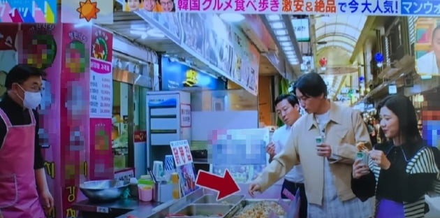 일본 개그맨 야마소에가 자신이 사용한 꼬치로 매대의 닭강정을 집어먹고 있다. 일본 TBS 방송화면 캡처