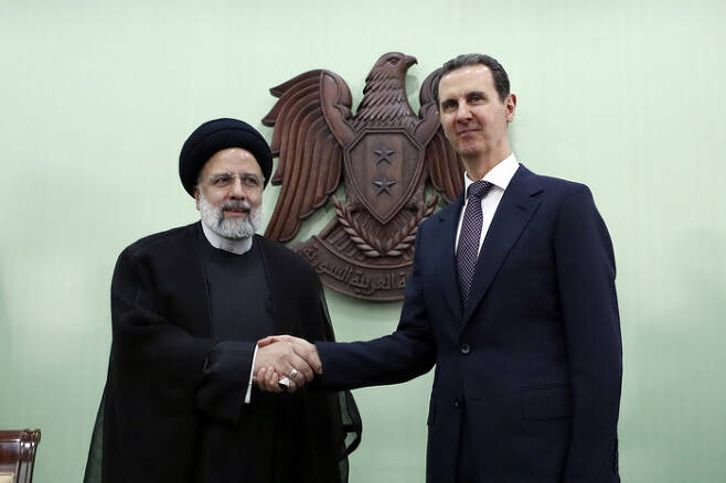 바샤르 알아사드(오른쪽) 시리아 대통령과 에브라힘 라이시 이란 대통령이 지난달 3일(현지시간) 시리아 수도 다마스쿠스에서 정상회담 전 악수를 하고 있다. AP연합뉴스