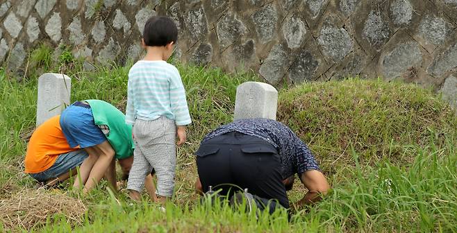 지난해 9월, 전북 전주 효자공원 묘지에서 아이들과 함께 조상 묘소를 찾은 한 시민이 절을 하고 있다. 사진은 기사 내용과 관계 없음. /뉴스1