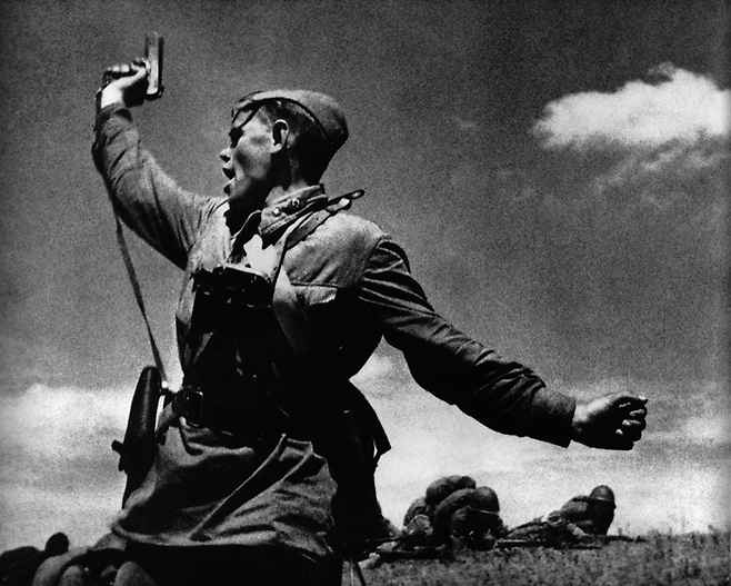 1942년 7월 남부 러시아 전선에서 소련군 소속의 한 젊은 정치장교가 병사들에게 돌격을 명령하고 있다. 군의 정치장교는 병사들이 국가에 대해 충성심을 유지하도록 하는 것이 주 임무다. 사진이 찍히고 몇 분 뒤 그는 전사했다. 교유서가 제공