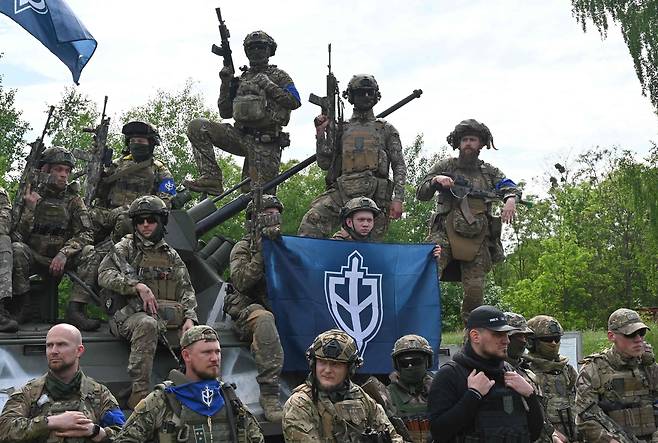 24일(현지시각) 러시아 국경과 가까운 우크라이나 북부의 한 숲에서 진행된 기자회견에 참석한 민병대원들의 모습./AFP 연합뉴스