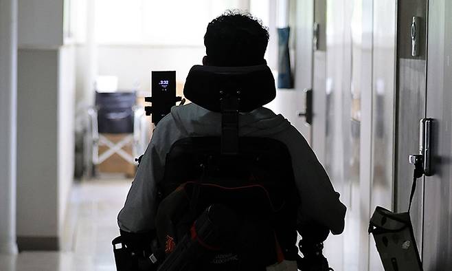 임 화가의 전동 휠체어가 어두컴컴한 복도를 지나 자택 겸 작업실로 향하고 있다.