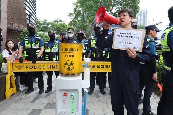 녹색연합 회원이 7일 오후 서울 종로구 일본대사관 앞에서 후쿠시마 핵오염수 방류의 위험성을 알리기 위해 정수기를 소재로 활용한 '누구도 마실 수 없는 핵오염수' 퍼포먼스를 벌이고 있다. 연합뉴스