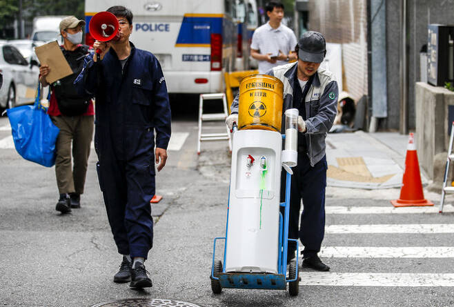 7일 오후 서울 종로구 일본대사관 인근에서 녹색연합 관계자들이 후쿠시마 오염수 방류 위험성을 강조하며 핵오염수가 담긴 정수기를 일본대사관으로 배달하는 퍼포먼스를 하고 있다. 뉴시스