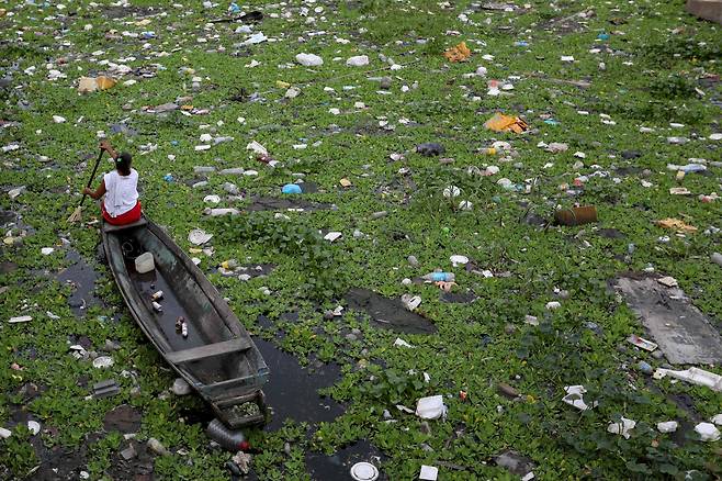 세계 환경의 날인 6월 5일 브라질 아마조나스주 마나우스시 에쿠칸도스 강에서 한 여성이 보트를 타고 쓰레기가 가득한 강위에서 알루미늄 캔을 수거하고 있다./AFP 연합뉴스