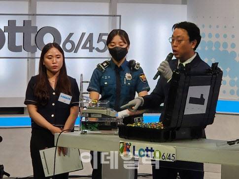 동행복권 직원과 경찰관이 10일 오후 7시께 서울 마포구 상암동 MBC 사옥 내 한 스튜디오에서 로또 공의 무게와 둘레를 측정하고 있다.(사진=황병서 기자)