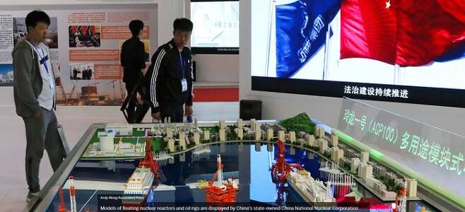 2017년 4월 중국 베이징에서 열린 ‘국제 원자력산업 전시회’에서 관람객들이 중국핵공업그룹(CNNC)이 선보인 부유식 원전과 석유굴착장치의 미니어처를 살펴보고 있다. ⓒ AP/연합뉴스