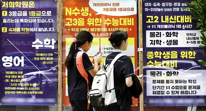 19일 서울 강남구 대치동 학원가에서 내신과 수능 교육과정 안내 문구가 빼곡하게 적혀 있는 한 학원 앞을 학생들이 지나가고 있다. 김호영 기자