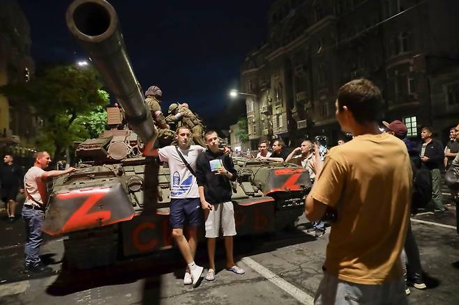 바그너 그룹 수장 예브게니 프리고진이 철수를 지시한 24일(현지시각) 병사들이 탱크에 앉아있는 가운데, 러시아 시민들이 그 앞에서 기념 사진을 찍고 있다. /AP 연합뉴스