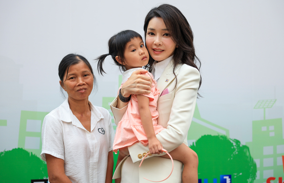 Korean first lady Kim Keon-hee meets a young patient at a local hospital cooperating with Smile for Children, a nonprofit organization for children with facial deformities, in Hanoi Saturday. [JOINT PRESS CORPS]