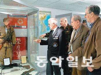 2010년 네덜란드 6·25전쟁 참전용사들이 스하르스베르헌시 반 호이츠 연대 6·25전쟁박물관 개관에 앞서 박물관에 전시된 중공군 마네킹을 보며 상념에 잠겨 있다. 마네킹 전투복과 무기는 전쟁 당시 노획한 것이다. 동아일보DB 