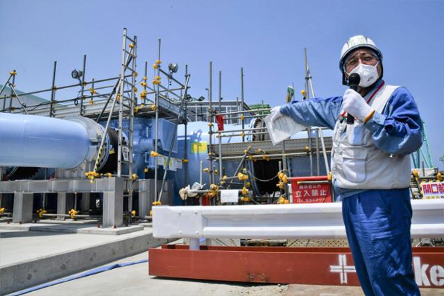 도쿄전력 직원이 26일 후쿠시마 원자력발전소에서 방사능 오염수 방류 시설에 관해 설명하고 있다. 후쿠시마=AP·연합뉴스