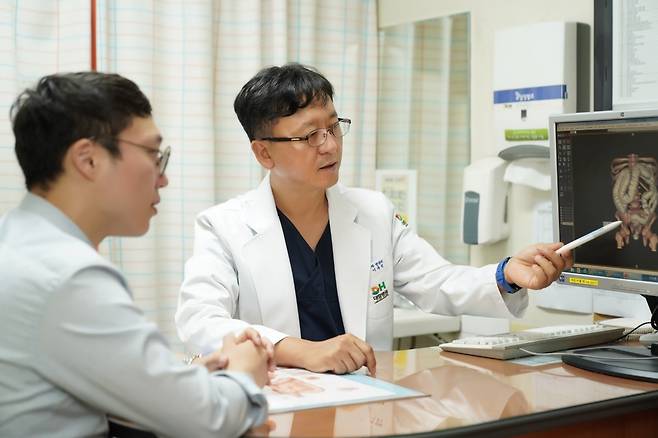 대항병원의 이두석 원장(대장항문학회 상임이사·오른쪽)이 환자에게 찾아온 배변 장애에 대해 설명하고 있다. 대항병원 제공