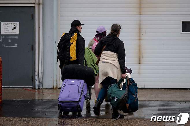 18일(현지시간) 캐나다 노스웨스트 준주 옐로나이프에서 주민들이 비상 대응 센터로 대피하고 있다. 정부는 지난 16일 해당 지역에 대피령을 내렸다. 2023.08.18/ ⓒ AFP=뉴스1 ⓒ News1 권진영 기자