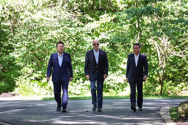 윤석열 대통령, 조 바이든 미국 대통령, 기시다 후미오 일본 총리가 지난 8월 18일(현지시간) 워싱턴 인근 미국 대통령 별장인 캠프 데이비드에서 한·미·일 정상 공동기자회견을 위해 오솔길을 걸어오고 있다. / 연합뉴스