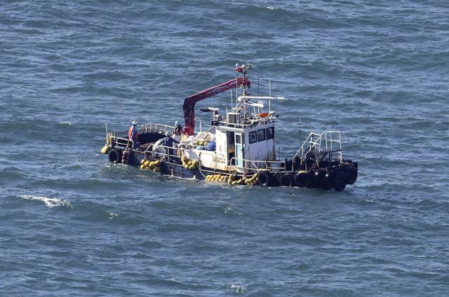 지난달 24일 일본 후쿠시마 제1원자력발전소 인근 해역에서 관측선이 해수의 방사성 물질을 검사하기 위해 샘플을 채취하고 있다. 일본은 이날 후쿠시마 오염수 방류를 개시했다. 오쿠마(후쿠시마현)=로이터 연합뉴스