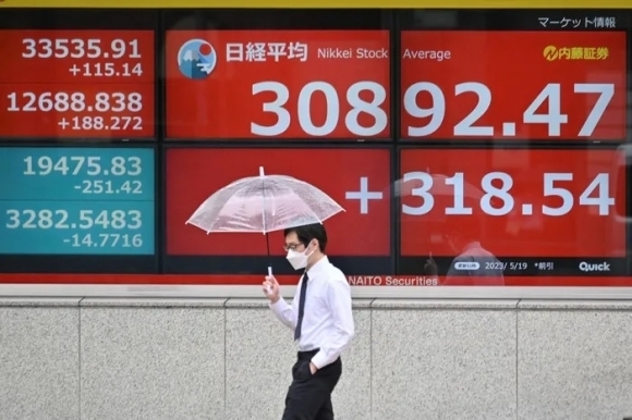 한 남성이 19일 일본 도쿄에서 일본 닛케이 지수가 표시된 전광판 앞을 지나가고 있다. 도쿄 AFP 연합뉴스
