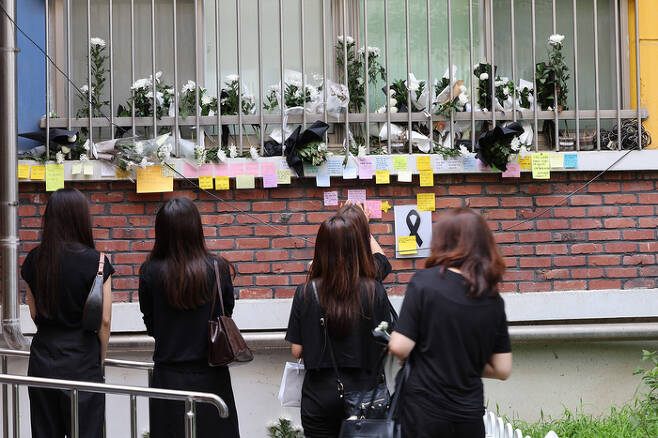 지난 7월 21일 오후 서울 서초구 서이초등학교를 찾은 추모객들이 고인에게 보내는 메시지들을 읽어보고 있다. | 연합뉴스