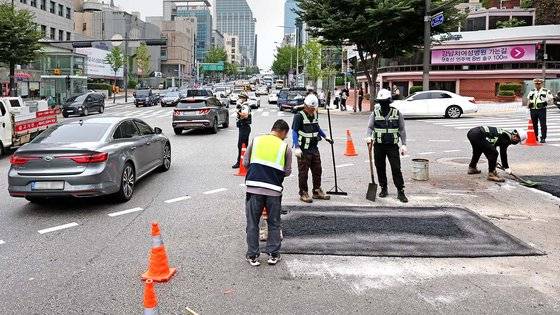 19일 서울 강남구 언주역 1~2번 출구앞 사거리에서 지름 1미터, 깊이 1.5미터 가량의 땅꺼짐(싱크홀) 현상이 발생해 관계자들이 복구작업을 하고 있다. 뉴스1