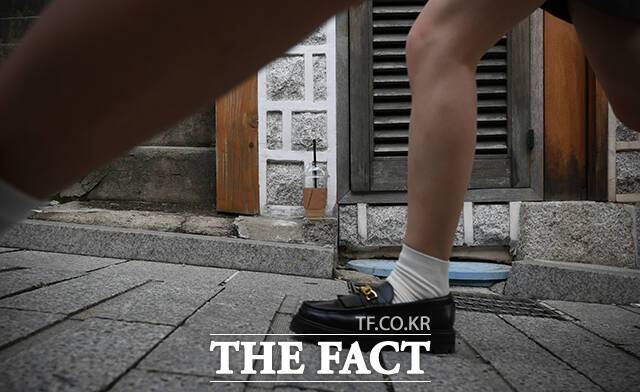 북촌한옥마을 담벼락에 빈 플라스틱 커피용기가 버려져 있다.