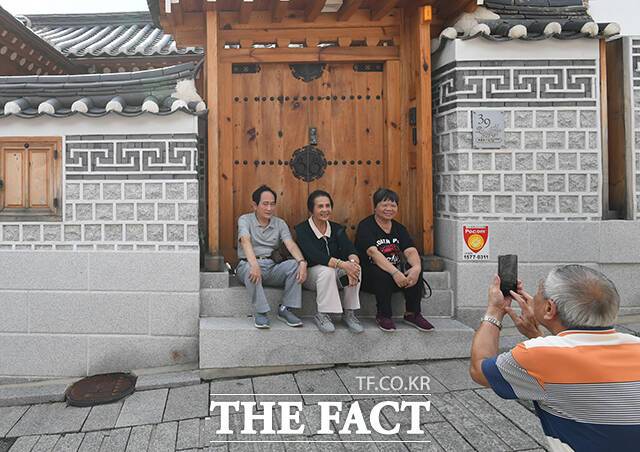 북촌한옥마을을 찾은 관광객들이 대문 앞에서 기념촬영을 하고 있다.