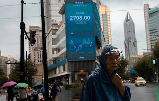 중국 상하이에서 증시 시황판 앞의 행인. 연합뉴스