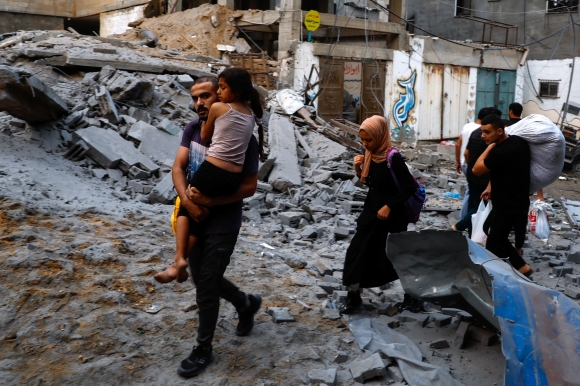 9일(현지시간) 팔레스타인 가자지구 알샤티 난민캠프가 이스라엘군의 폭격으로 파괴된 후 팔레스타인 사람들이 대피하고 있다. 2023.10.9 로이터 연합뉴스