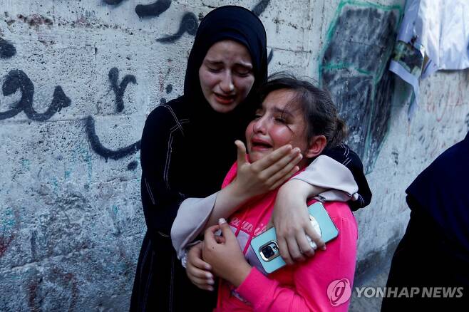 전쟁 속 아버지 잃고 슬퍼하는 팔레스타인 아이 (칸유니스 로이터=연합뉴스) 10일(현지시간) 팔레스타인 가자지구 남부 칸 유니스에서 무장 정파 하마스에 소속된 간부의 장례식이 열린 가운데 그의 딸이 한 여성에게 위로받고 있다. 이스라엘군(IDF)은 이날 가자지구에 공습을 가해 하마스의 고위 간부 2명을 사살했다고 밝혔다. 2023.10.11 besthope@yna.co.kr