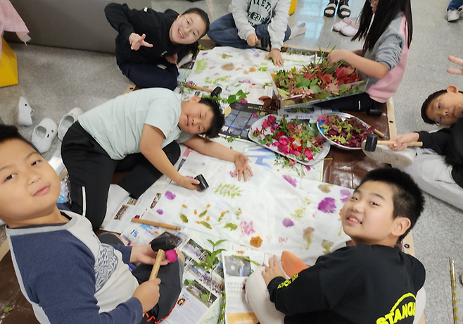 학생들이 '마음정원코너'에서 풀과 꽃 등을 활용해 천연 염색 손수건 만들기를 하고 있는 모습. ⓒ