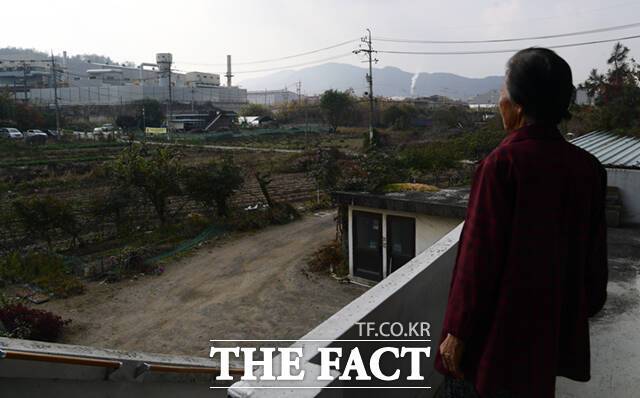대전리 마을에서 60년 넘게 살고 있는 주민 홍 모 할머니(82)가 자신의 집 앞에 우뚝 솟은 SRF 열병합발전소 건물을 바라보고 있다. 그는 인근 공장에서 매연들이 들어와 매일같이 옥상과 집 건물이 까맣게 된다고 하소연하며 SRF 소각장이 가동되면 얼마나 더 심해질지 걱정이라고 했다.