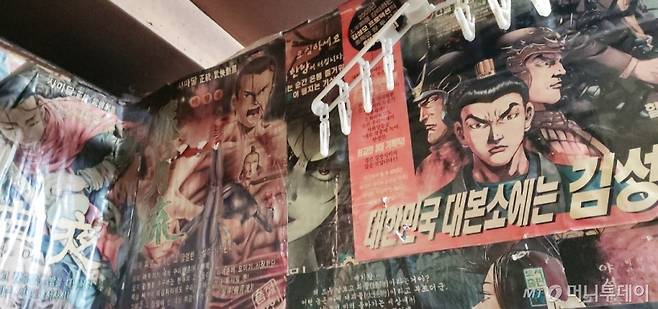 서울 용산구 동자동에 있는 경일만화 입구에 들어서면 노랗게 변색된 만화 포스터가 벽에 붙어있다. 벽 상단에는 빨래 옷걸이가 걸려있다. /사진=정진솔 기자