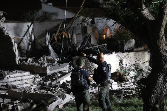 2일(현지시간) 가자지구에서 하마스가 발사한 로켓에 의해 파손된 텔아비브 외곽 지역을 확인하는 이스라엘 보안군 대원들. AFP=연합뉴스