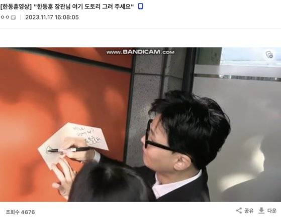 지난 17일 대구 방문 당시 “도토리를 그려달라”는 팬에게 “그냥 먹는 도토리 말예요?”라며 그림을 그려주는 한동훈 장관. 사진 디시인사이드 캡처