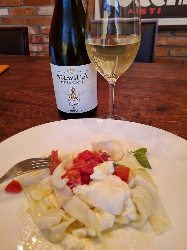 데 마리아 셰프의 시그니처 전채요리인 ‘갑오징어 탈리아텔레아 부라타 치즈’와 하우스 화이트 와인.