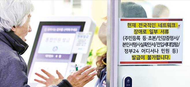 < 항의하는 민원인 > 17일 서울 종로구청 직원이 민원인에게 네트워크 장애로 인해 서류를 발급할 수 없다고 설명하고 있다. 민원실 출입문과 통합무인민원발급기에는 네트워크 장애 안내문이 붙어 있다. /임대철 기자