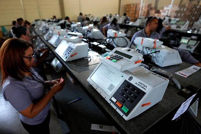 브라질 수도 브라질리아에서 지난 10월 대선 결선투표를 앞두고 당국자들이 전자투표기를 점검하는 모습. 브라질은 100% 전자 투표를 실시한다. /AP 연합뉴스