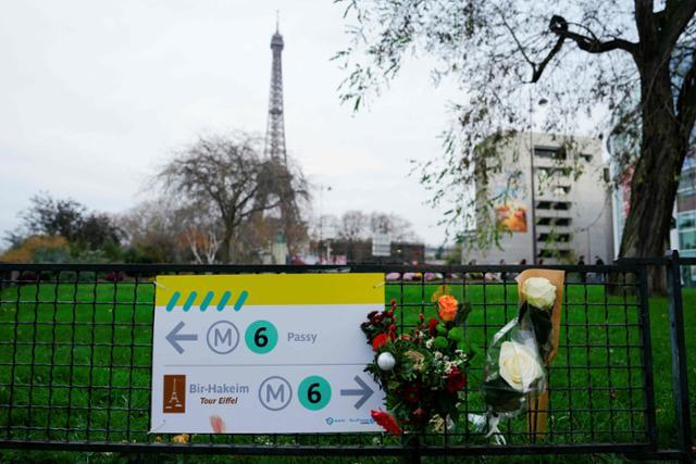 3일 프랑스 파리 에펠탑 인근 공원 철조망에 전날 이슬람 극단주의자가 휘두른 흉기에 찔려 사망한 관광객을 추모하는 꽃다발이 걸려 있다. 파리=AFP 연합뉴스