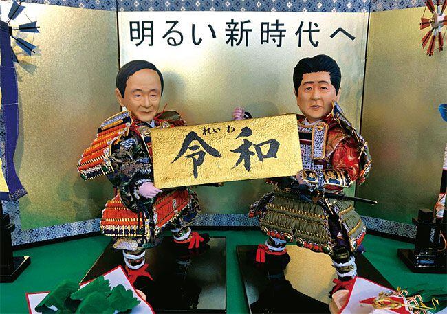 나루히토 일왕의 새 연호 ‘레이와’를 들고 있는 스가 장관(왼쪽)과 아베 총리를 묘사한 전통 인형. /뉴시스