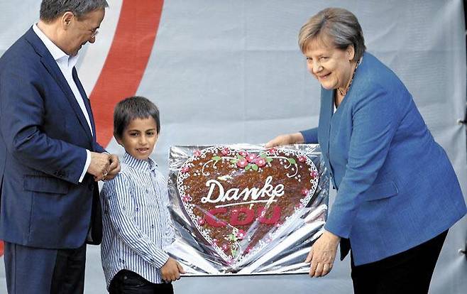 총선 유세중‘고마워요’케익 받는 메르켈 - 앙겔라 메르켈(오른쪽) 독일 총리가 총선 하루 전인 25일(현지 시각) 서부 도시 아헨에서 유세 중‘고마워요(Danke) CDU(기독민주당)’라는 글이 적힌 케이크를 건네받고 있다. 맨 왼쪽은 기민·기사당 총리 후보인 아르민 라셰트 당 대표. /AFP 연합뉴스
