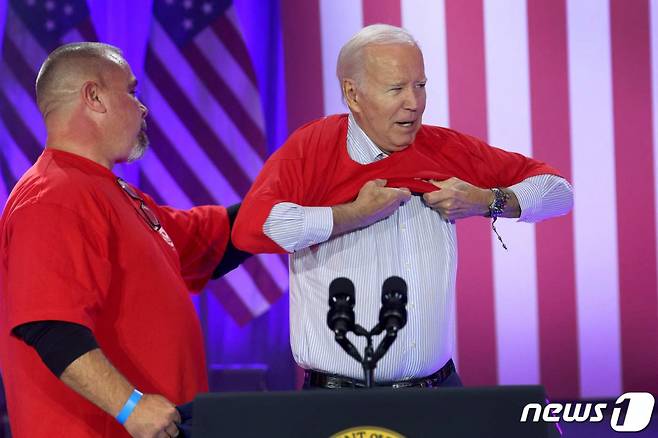 (벨베디어 AFP=뉴스1) 우동명 기자 = 조 바이든 미국 대통령이 9일(현지시간) 일리노이주 벨베디어에서 열린 전미자동차노조(UAW) 행사에 도착해 붉은색 UAW 셔츠로 갈아 입고 있다. 2023.11.10 ⓒ AFP=뉴스1 Copyright (C) 뉴스1. All rights reserved. 무단 전재 및 재배포, AI학습 이용 금지.