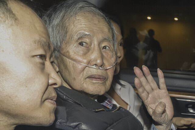 페루의 은퇴한 독재자 알베르토 후지모리(가운데)가 2023년 12월6일 석방된 뒤 산소공급기를 단 채 차를 타고 집으로 향하고 있다. 앞쪽이 아들 겐지, 뒤쪽이 딸 게이코로 둘 다 페루에서 영향력이 큰 정치인이다. AFP 연합뉴스